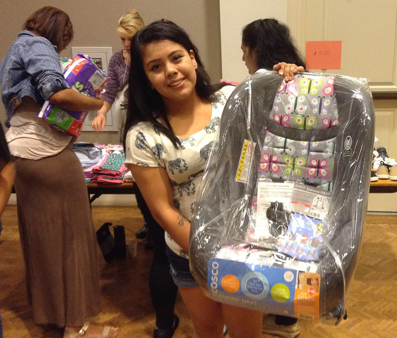 young mother holding baby carrier